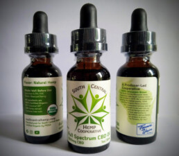 Three CBD oil bottles in a triangle formation displaying each part of the label.